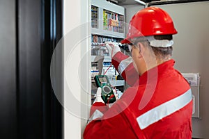 Electricity and electrical maintenance service, Engineer hand holding AC voltmeter checking electric current voltage