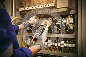 Electricity or electrical maintenance service, Engineer hand holding voltmeter checking electric current voltage at circuit