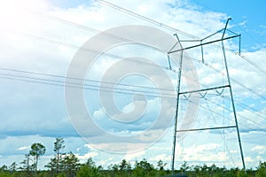 electricity lines on blue sky background. high-voltage power lines on transmission tower, energy voltage and sun shining