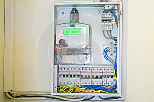 The electricity meter is in the electrical box. Electric cabinet with wires and circuit breakers. Electricity counter coupled to