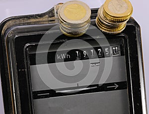 Electricity meter and the euro coins above with the text KWH