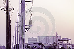 Electricity pole against sunset sky and factory building backgorund