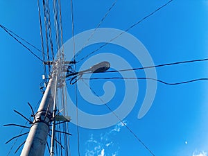 Electricity pole with wire against blue sky