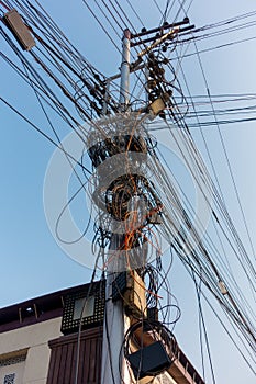 Electricity poles with overcrowded wires and distribution box in India