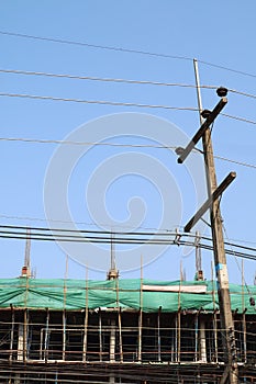 Electricity post and underconstruction building