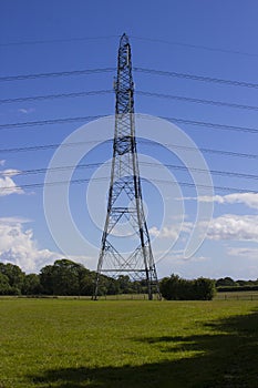 Electricity power cables and pylons stretching across the English countryside as a vital part of the National Grid electricity dis