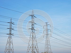 Electricity power line on high voltage transmission towers over blue sky and white cloud background