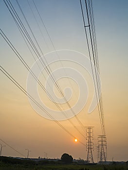 Electricity power lines and pylons at sunset.