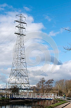 Electricity pylon against a blue cloudy sky. Copy space.
