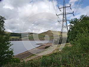 Electricity pylon on bank of Reservoir with very low water