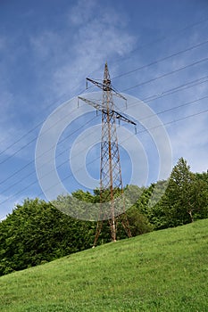 Electricity pylon in green meadow in spring