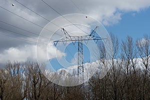 Electricity pylon and power lines on blue cloudy sky