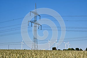 Electricity pylon with  power lines and wind turbines