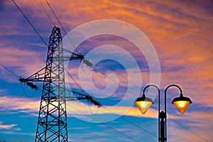 Electricity pylon and streetlamp at sunset