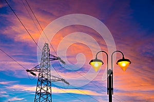 Electricity pylon and streetlamp at sunset