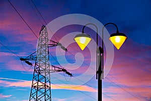 Electricity pylon and streetlamp at sunset