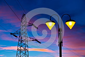 Electricity pylon and streetlamp at sunset