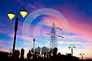 Electricity pylon and streetlamp at sunset