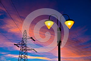Electricity pylon and streetlamp at sunset