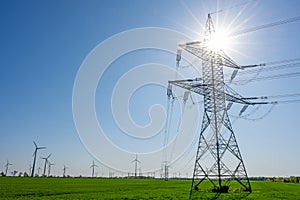 An electricity pylon with the sun behind it