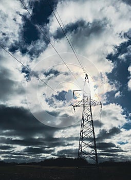 Electricity pylon with the sun behind and dramatic cloudscape