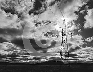 Electricity pylon with the sun behind and dramatic cloudscape