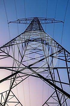 Electricity pylon at sunrise in front of blue pink sky