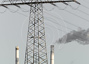 Electricity pylon with two chimneys and smoke from one chimney