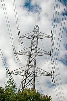 Electricity pylons against a blue and white sky. Large grey pylon, National Grid