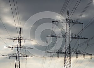 Electricity pylons against dark clouds