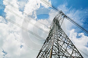 Electricity pylons with blue sky and white clouds. High voltage grid tower with wire cable at distribution station. High voltage