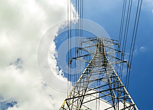 Electricity pylons with blue sky and white clouds. High voltage grid tower with wire cable at distribution station. High voltage