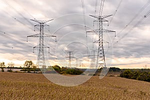 Electricity pylons in the countryside under cloudy sky