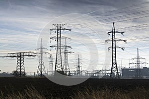 Electricity pylons with distribution power station blue cloudy sky background