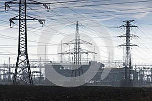 Electricity pylons with distribution power station blue cloudy sky background