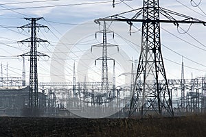Electricity pylons with distribution power station blue cloudy sky background