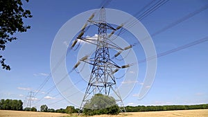 Electricity pylons in a field with blue sky. England UK