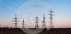 Electricity pylons and lines at dusk.