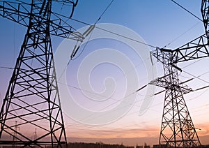 Electricity pylons and lines at dusk.