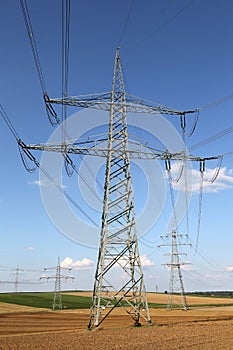 Electricity pylons and lines on a field