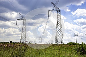 Electricity pylons over a green field.