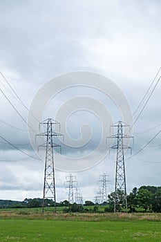 Electricity pylons straddling farmland in Devon UK