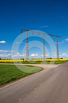 Electricity pylons and wires crossing rural roads and farmlands in SkÃ¥ne Sweden