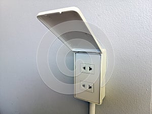 Electricity socket installed on white concrete wall