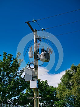 An electricity supply pylon delivering power through the UK national grid showing power cables, isolators and other equipment.