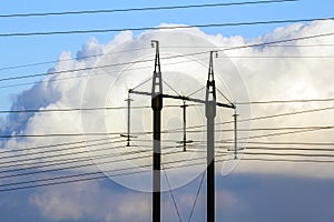 Electricity transmission power lines against white clouds. High