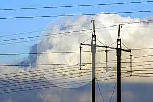 Electricity transmission power lines against white clouds. High