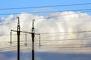 Electricity transmission power lines against white clouds. High