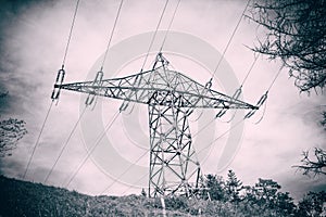 Electricity transmission power lines and post against blue sky at mountain