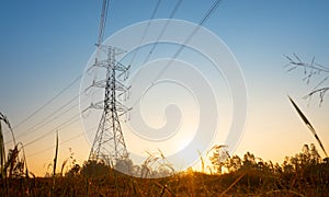 Electricity transmission power tower over sunset sky background